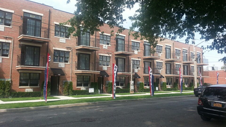 A row of brick buildings on the side of a street.