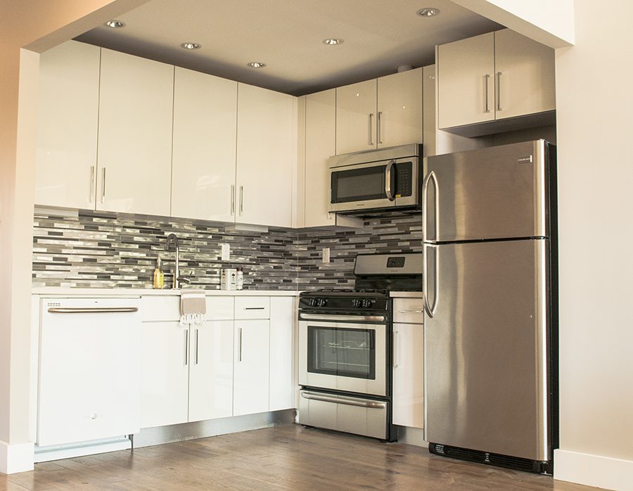 A kitchen with white cabinets and stainless steel appliances.