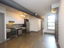 A kitchen with stainless steel appliances and wooden floors.