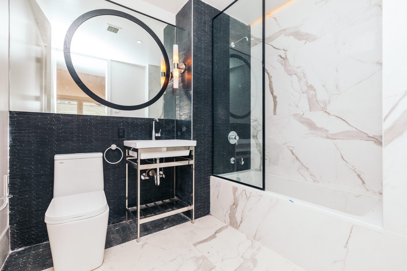 A bathroom with black and white marble walls