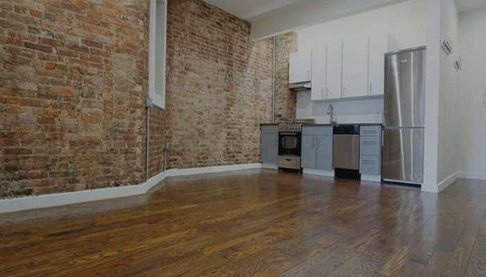A kitchen with brick walls and wooden floors