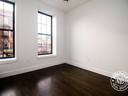 A room with dark wood floors and white walls.